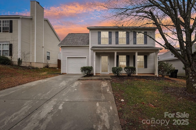 view of property featuring a garage, a porch, and a yard