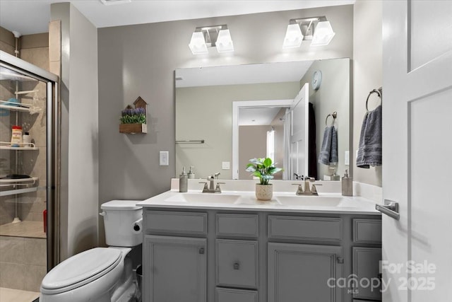 bathroom with vanity, a shower with shower door, and toilet