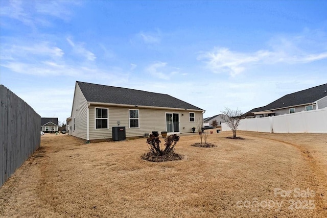 back of house featuring a yard and central AC unit