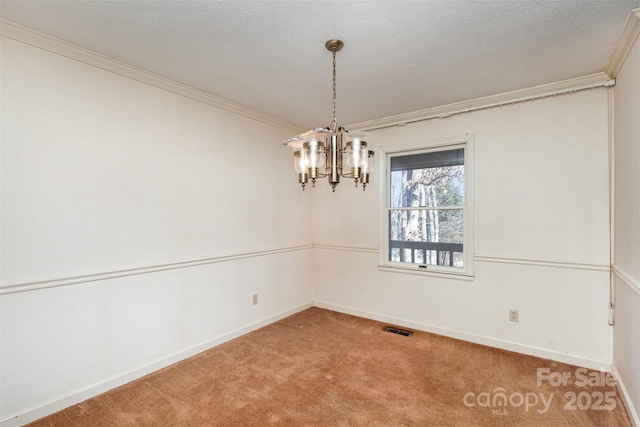 carpeted spare room featuring ornamental molding, a textured ceiling, and a notable chandelier