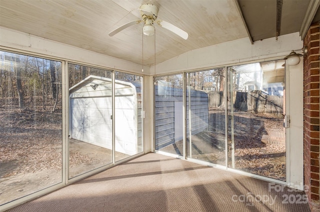 unfurnished sunroom with ceiling fan, plenty of natural light, and vaulted ceiling