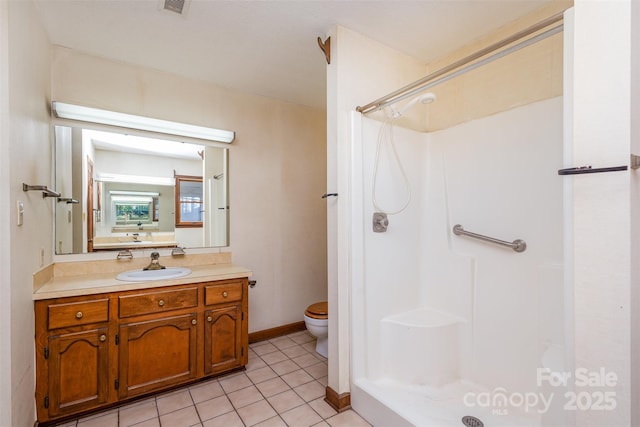 bathroom with tile patterned flooring, vanity, toilet, and walk in shower