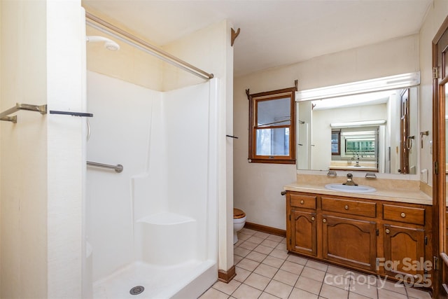 bathroom with tile patterned flooring, vanity, toilet, and walk in shower