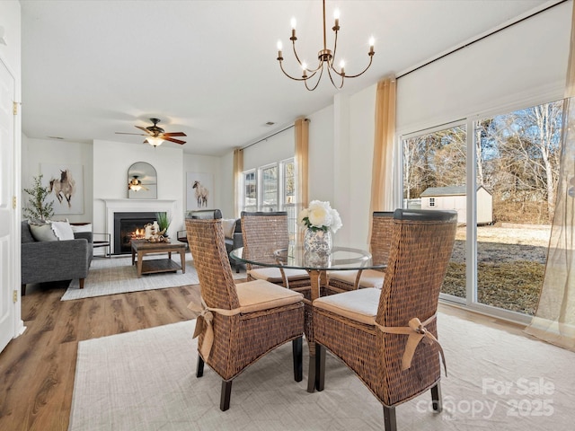 dining room with ceiling fan with notable chandelier and hardwood / wood-style floors