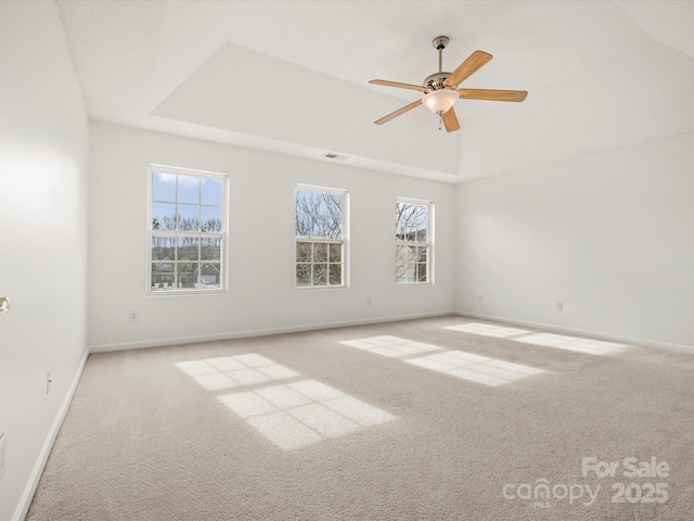 unfurnished room with light colored carpet, ceiling fan, and a tray ceiling