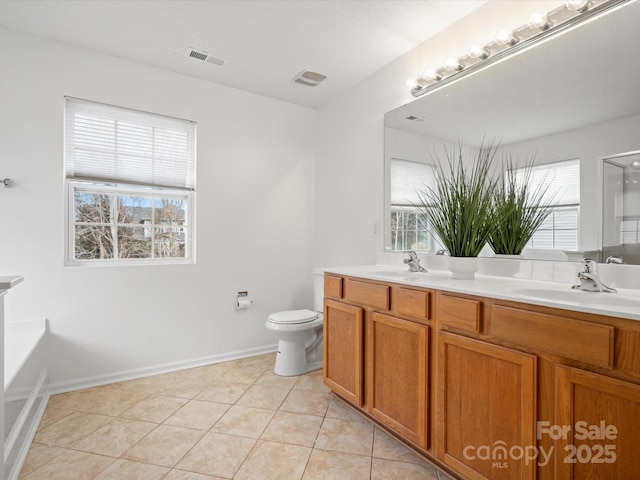 bathroom with a tub to relax in, tile patterned floors, vanity, and toilet