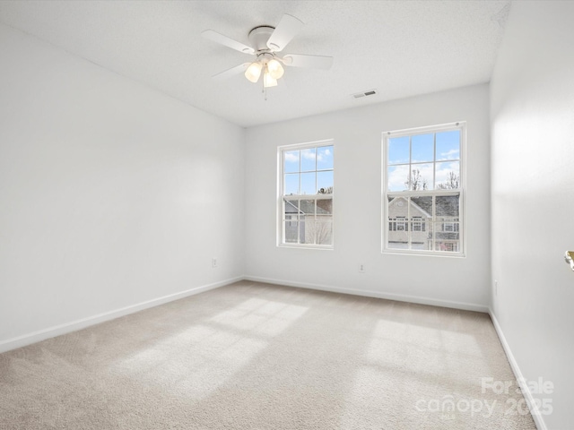 carpeted empty room with a textured ceiling and ceiling fan