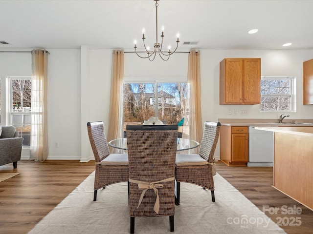 dining area featuring sink, hardwood / wood-style flooring, and a chandelier