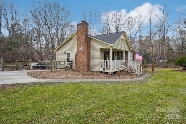 view of side of property featuring a lawn and a porch