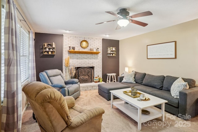 carpeted living room featuring a brick fireplace and ceiling fan