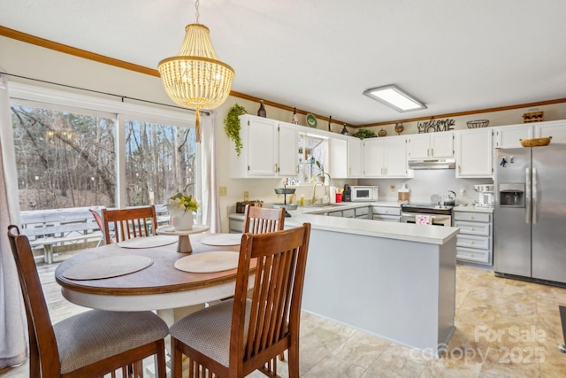 kitchen featuring white cabinetry, stainless steel appliances, sink, and hanging light fixtures