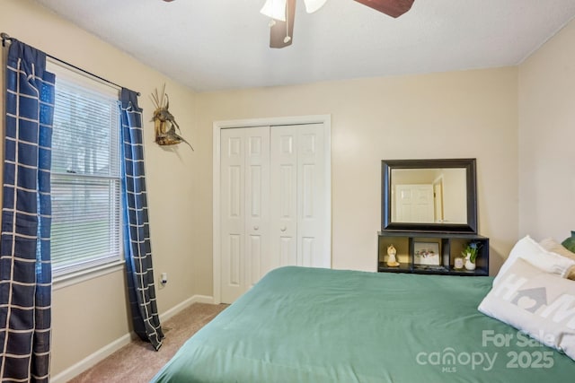 carpeted bedroom with ceiling fan and a closet