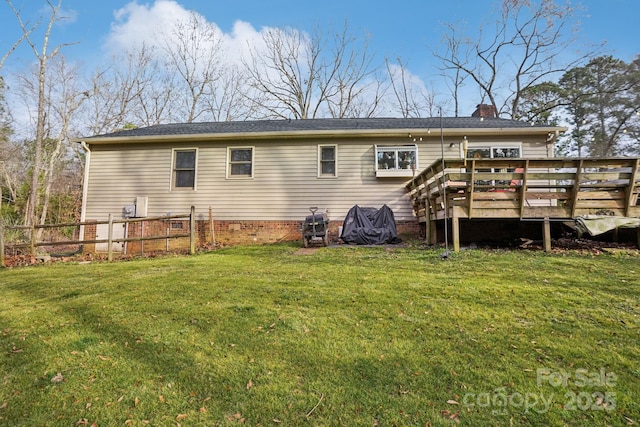 rear view of property with a deck and a lawn