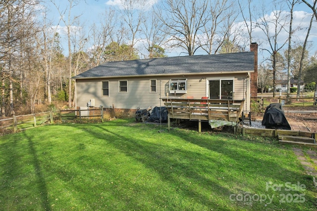 rear view of house featuring a wooden deck and a yard