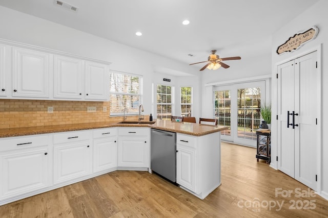 kitchen with white cabinetry, sink, stainless steel dishwasher, and kitchen peninsula