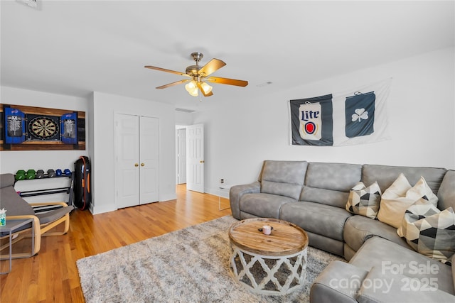 living room with wood-type flooring and ceiling fan