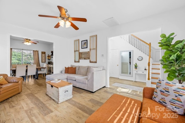 living room with ceiling fan and light hardwood / wood-style flooring