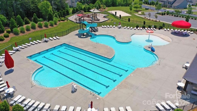 view of pool featuring a water slide, a patio area, and a lawn