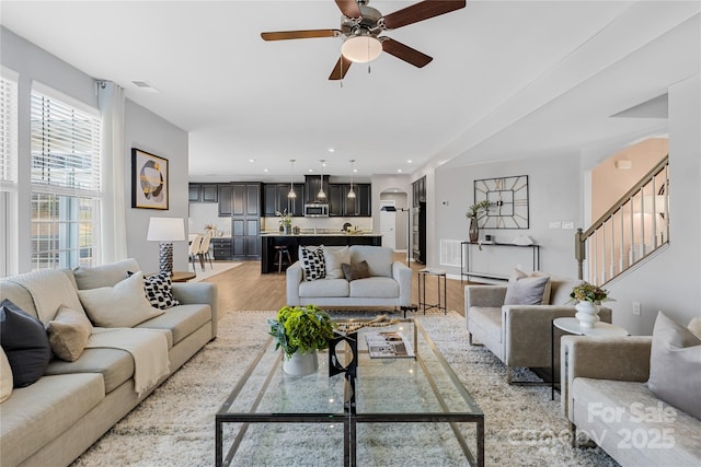 living room with ceiling fan and light wood-type flooring