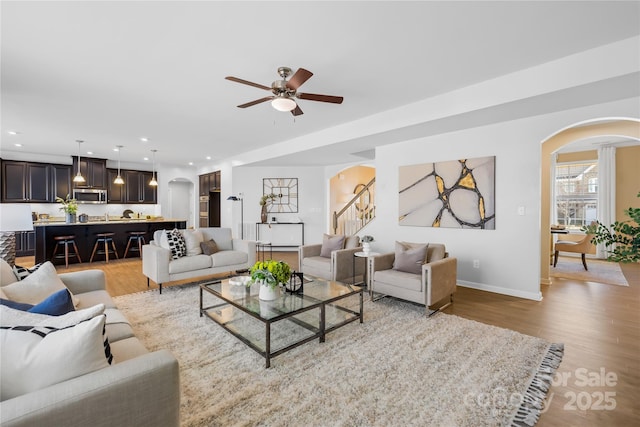 living room featuring ceiling fan and light hardwood / wood-style flooring