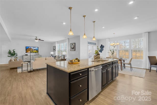 kitchen with sink, dishwasher, a kitchen island with sink, and hanging light fixtures