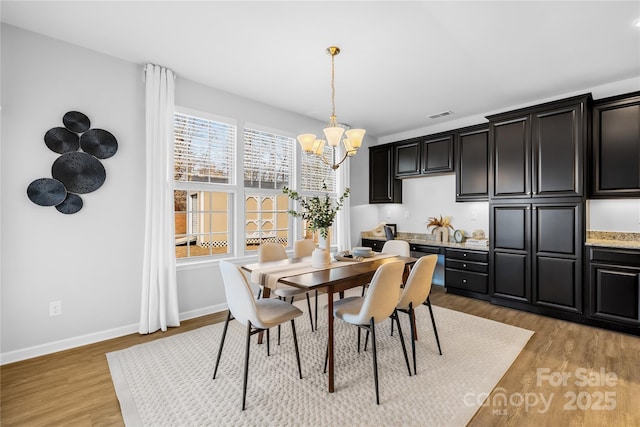 dining room with a chandelier and light hardwood / wood-style floors