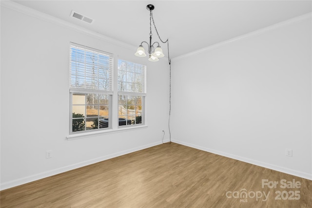 unfurnished dining area featuring an inviting chandelier, ornamental molding, and hardwood / wood-style flooring