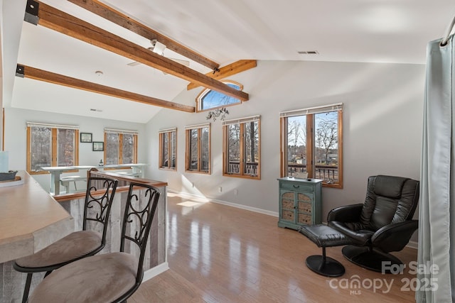 dining room featuring light hardwood / wood-style floors and vaulted ceiling with beams