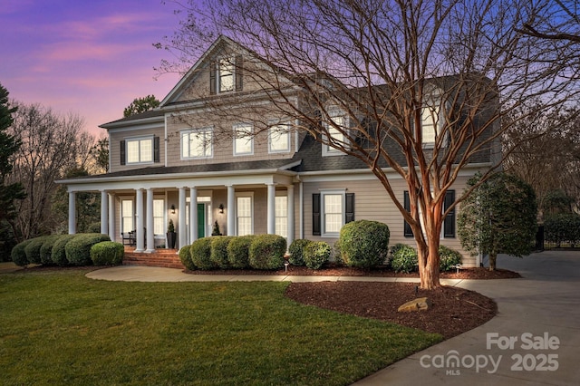 view of front of house with a porch and a lawn