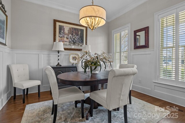 dining room featuring ornamental molding, dark hardwood / wood-style flooring, and a chandelier