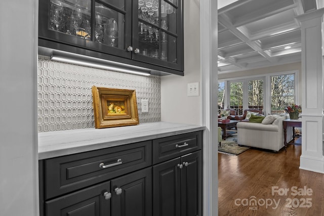 bar with coffered ceiling, light stone counters, dark hardwood / wood-style flooring, beamed ceiling, and decorative backsplash