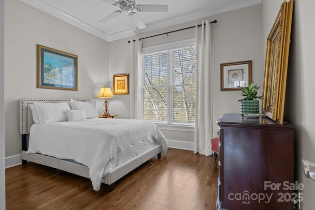 bedroom with crown molding, ceiling fan, and dark hardwood / wood-style floors