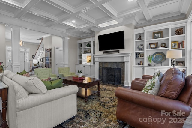 living room with coffered ceiling, beam ceiling, a tiled fireplace, and decorative columns