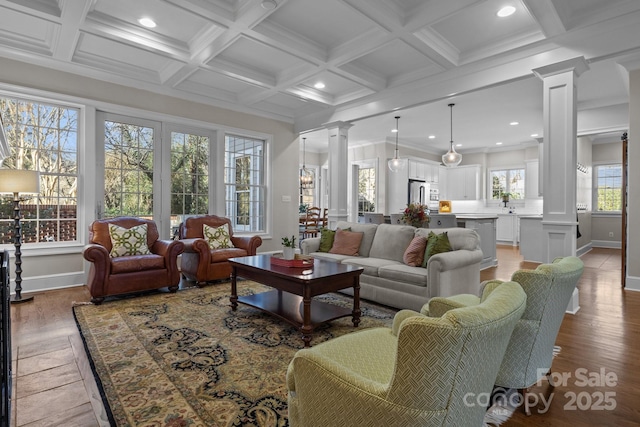 living room with hardwood / wood-style floors, decorative columns, ornamental molding, coffered ceiling, and beam ceiling