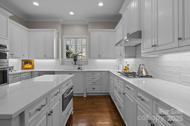 kitchen with light stone counters, stainless steel appliances, sink, and white cabinets