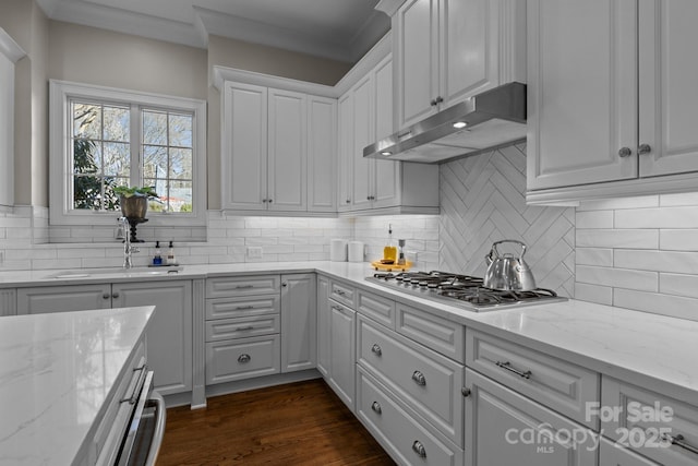 kitchen featuring light stone counters, dark hardwood / wood-style floors, stainless steel gas cooktop, and white cabinets