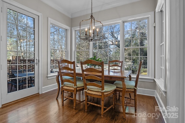 dining room featuring crown molding, a notable chandelier, and hardwood / wood-style flooring