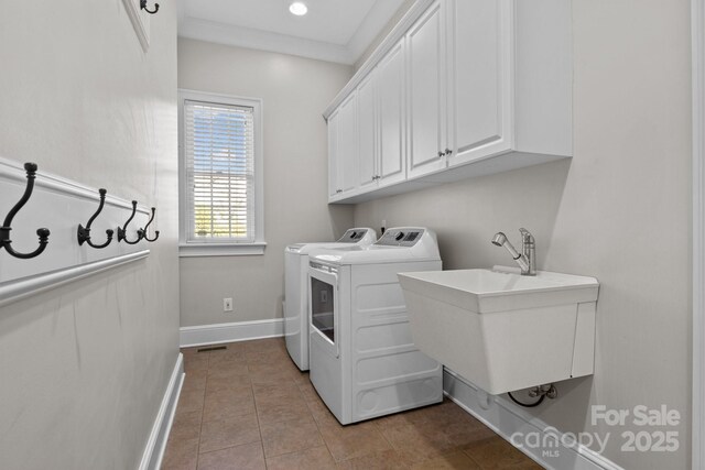 clothes washing area featuring cabinets, sink, washing machine and dryer, and light tile patterned floors