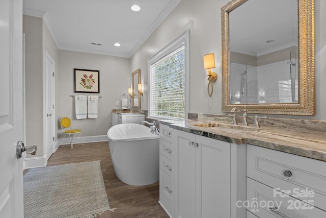 bathroom with vanity, crown molding, wood-type flooring, and plus walk in shower