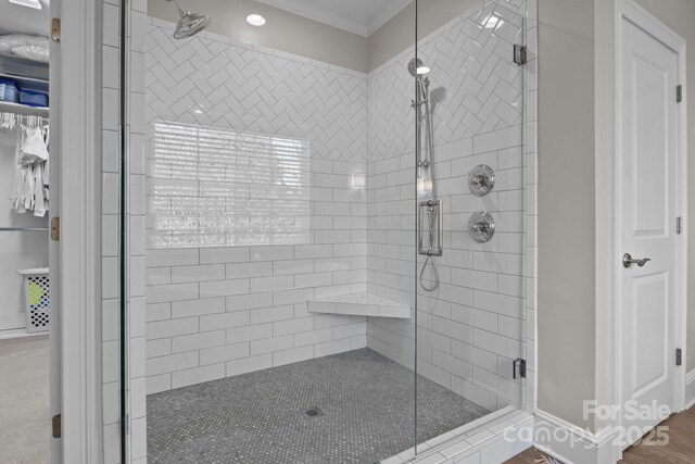 bathroom with ornamental molding and walk in shower