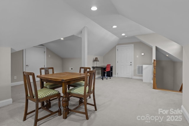 dining space featuring lofted ceiling and light carpet