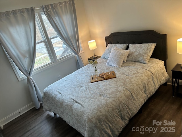 bedroom featuring dark wood-style floors and baseboards