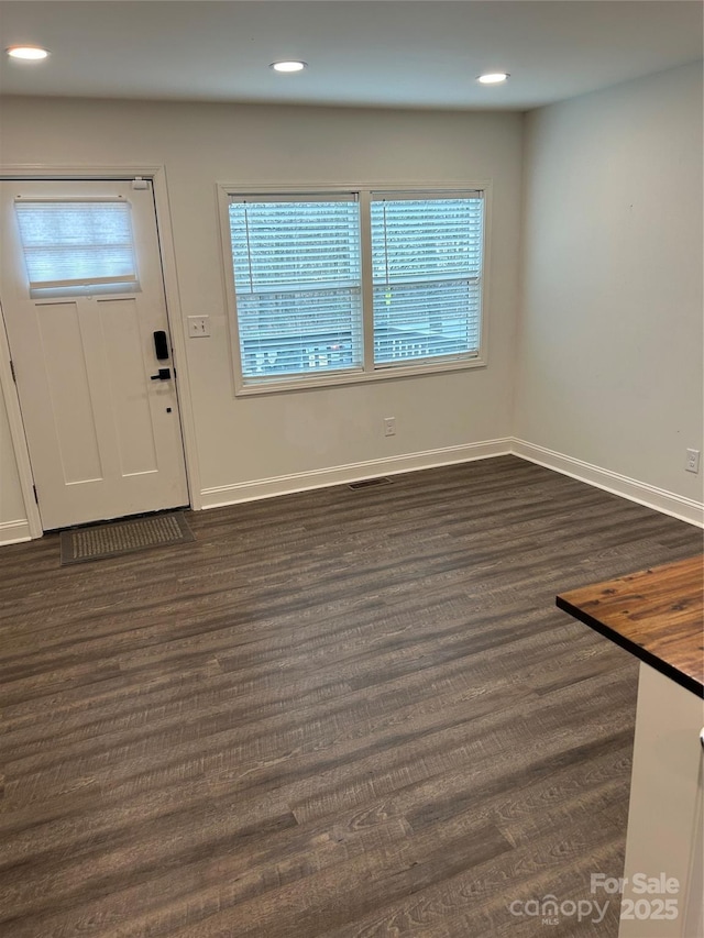 foyer with baseboards, dark wood finished floors, and recessed lighting