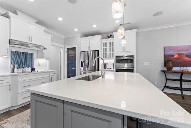 kitchen featuring a large island with sink, white cabinetry, and appliances with stainless steel finishes