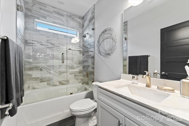 full bathroom with toilet, vanity, and shower / bath combination with glass door