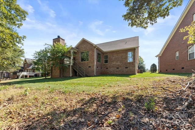 rear view of house featuring central AC unit and a lawn