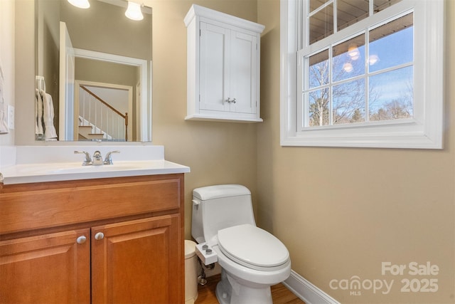 bathroom featuring vanity, toilet, and baseboards