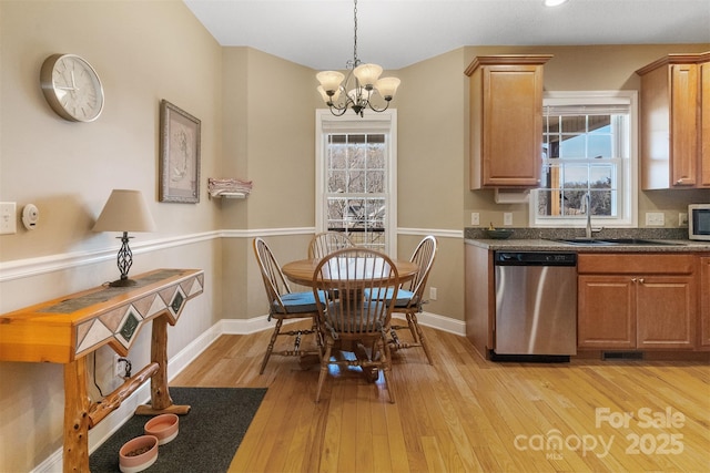 dining room featuring a healthy amount of sunlight, light wood-style flooring, and baseboards