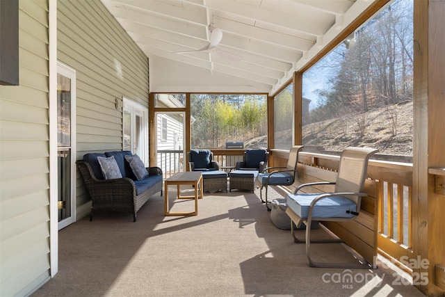 sunroom / solarium featuring vaulted ceiling with beams