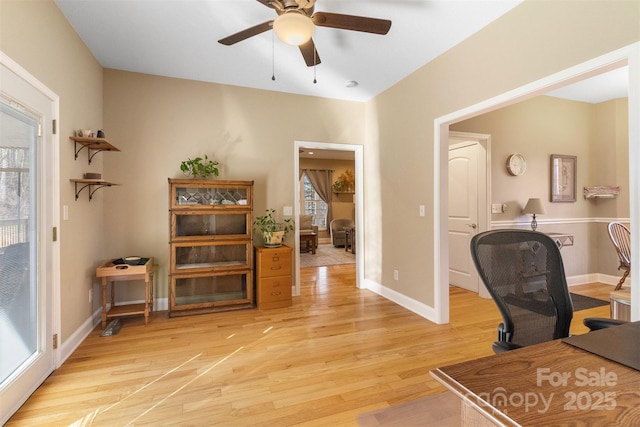 office area with light wood-style floors, ceiling fan, and baseboards